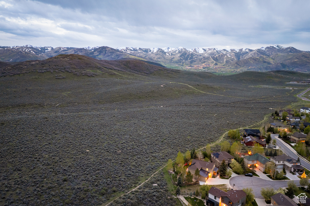 Aerial view of property and surrounding area featuring a mountain backdrop and nearby suburban area
