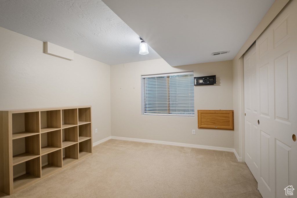 Unfurnished bedroom with light carpet, baseboards, and a closet