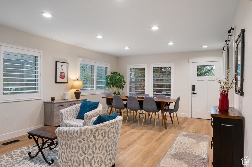 Living area with light wood-type flooring, a barn door, recessed lighting, and baseboards
