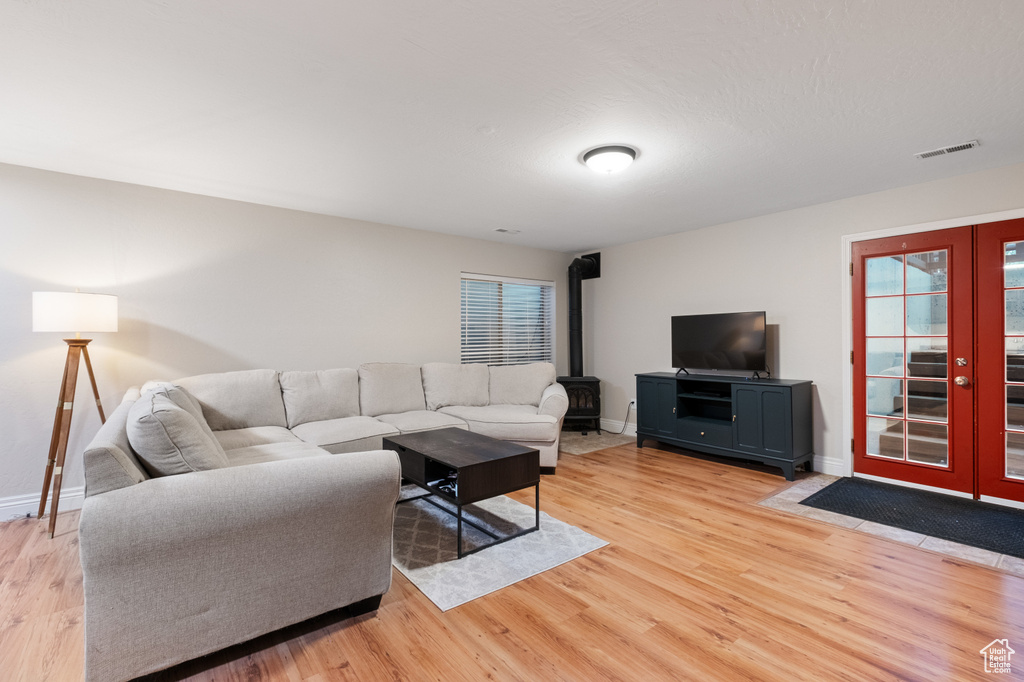 Living room featuring french doors, light wood-style flooring, and baseboards