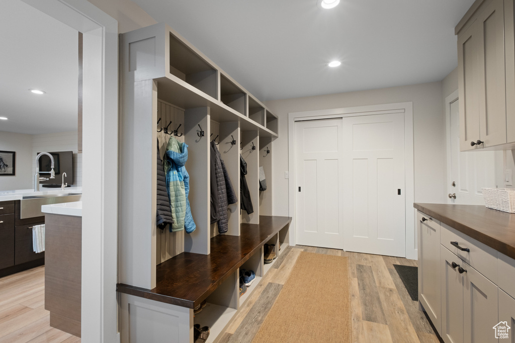 Mudroom featuring light wood-style flooring, recessed lighting, and a sink