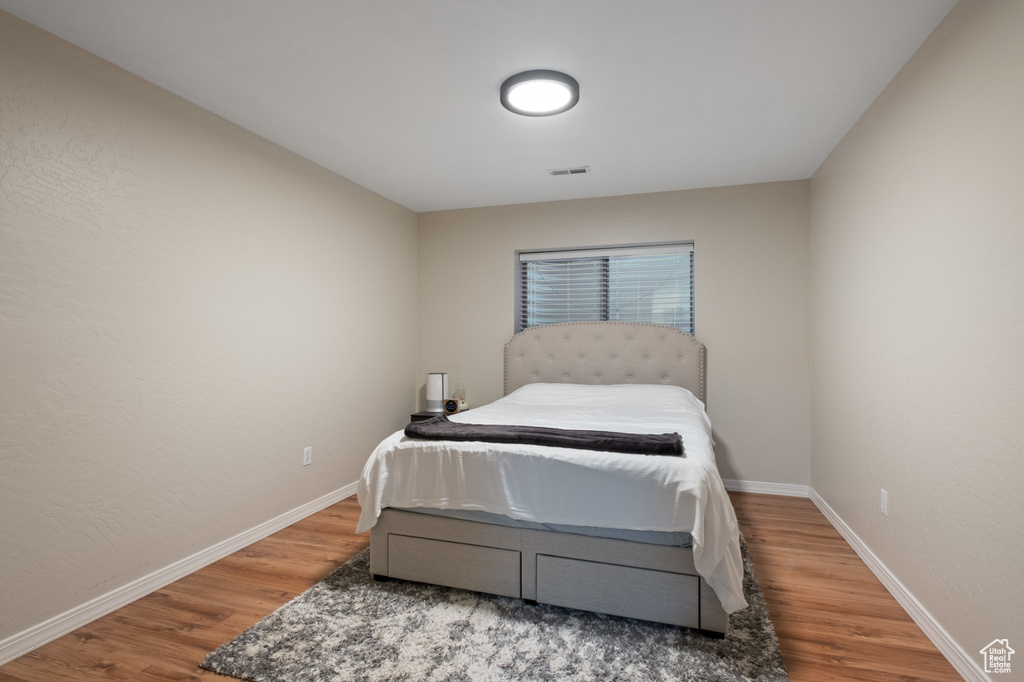 Bedroom featuring wood finished floors and baseboards