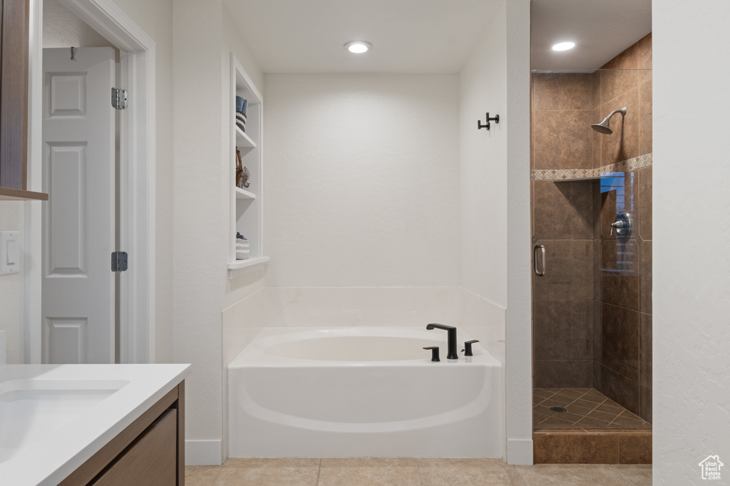 Full bath featuring a stall shower, a garden tub, vanity, and recessed lighting
