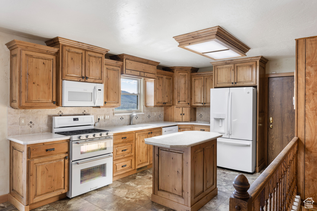 Kitchen featuring white appliances, a sink, decorative backsplash, and light countertops
