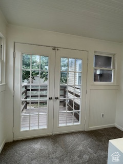 Doorway featuring healthy amount of natural light, french doors, and dark colored carpet