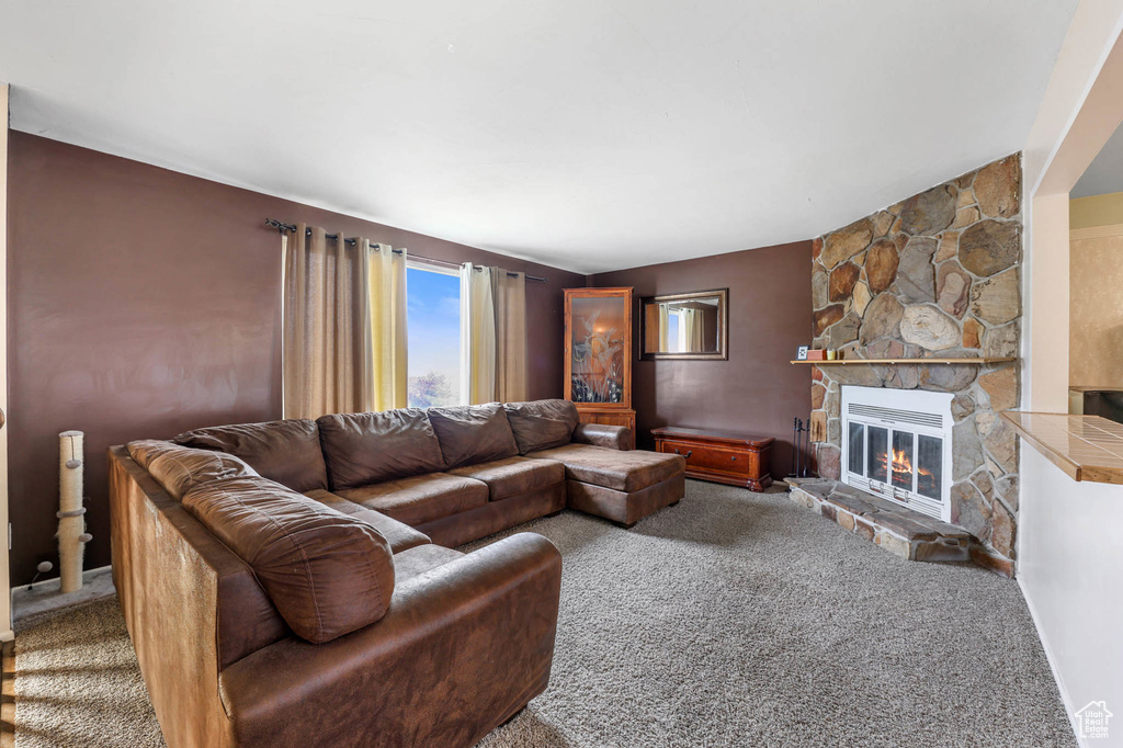 Living area with carpet flooring and a stone fireplace