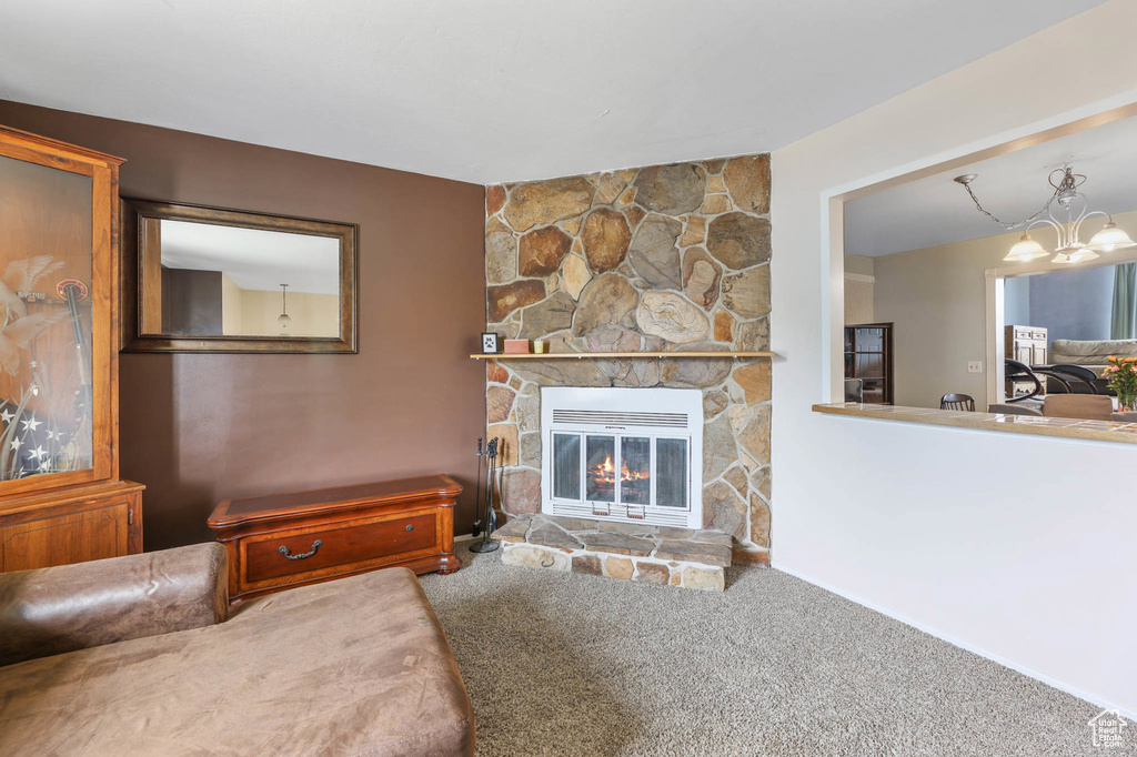 Living area featuring a chandelier, carpet, and a fireplace