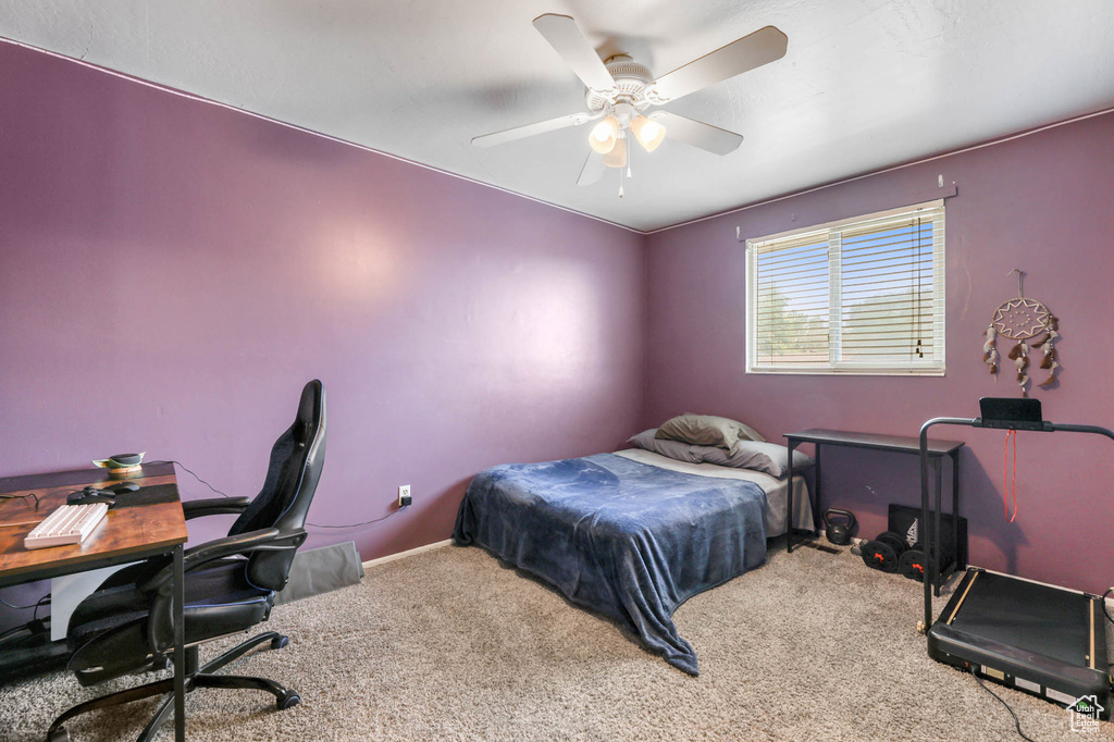 Carpeted bedroom featuring a desk, baseboards, and ceiling fan
