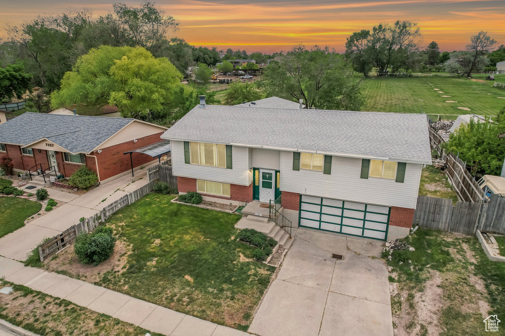 View of front of house featuring concrete driveway, an attached garage, and brick siding