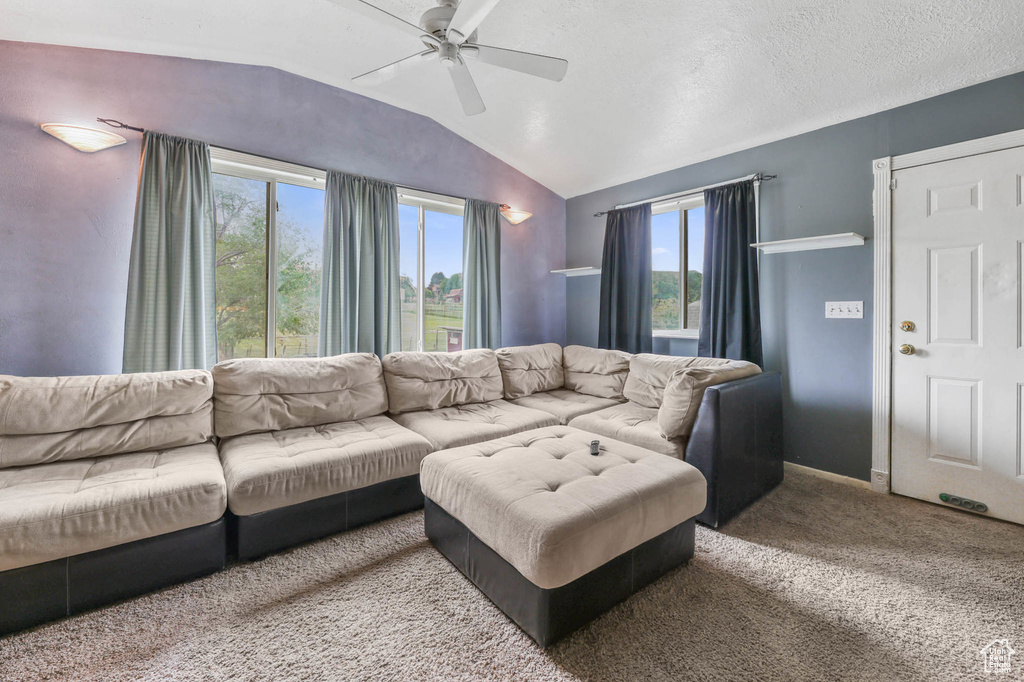 Living area with ceiling fan, lofted ceiling, and carpet floors