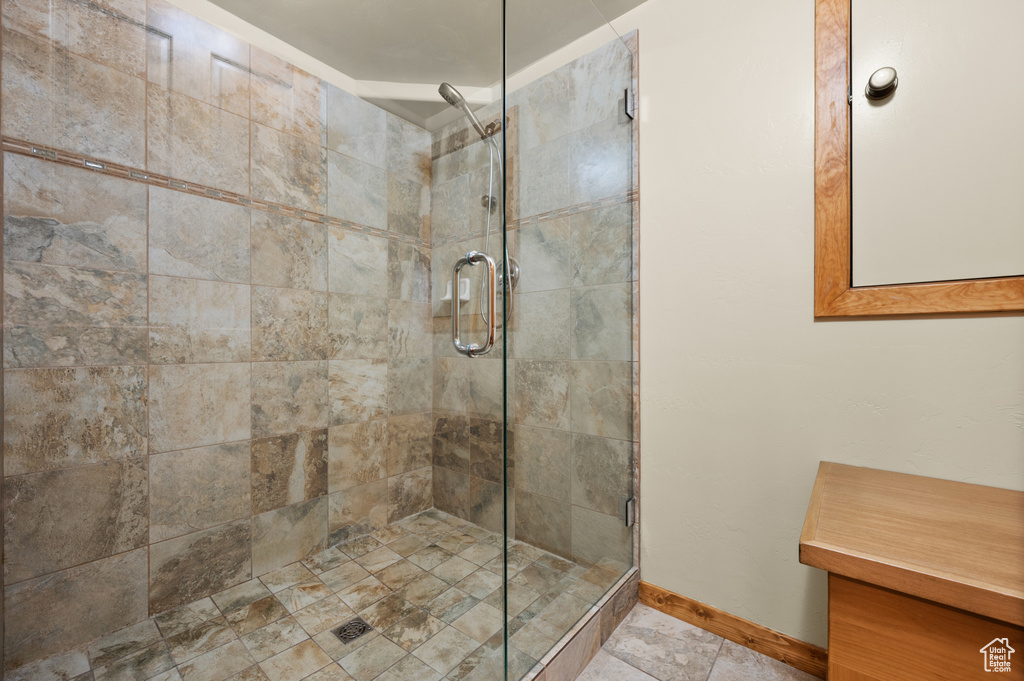 Full bathroom featuring baseboards and a shower stall
