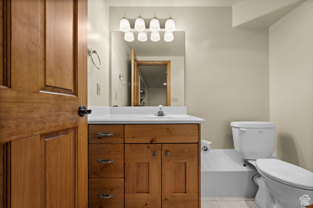 Bathroom featuring toilet, tile patterned floors, and vanity