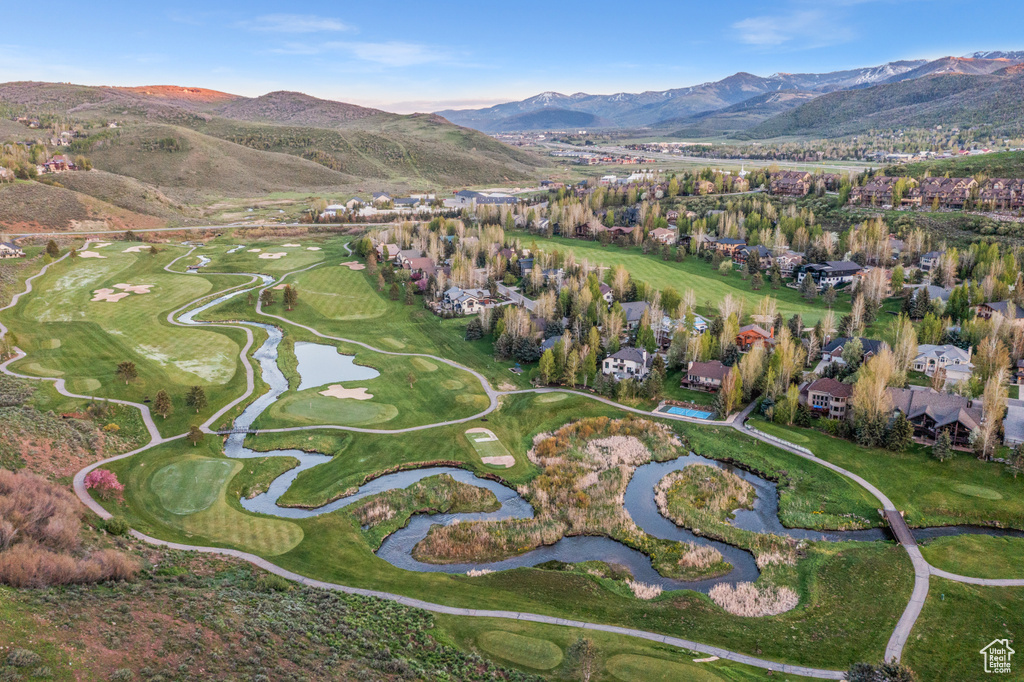 Aerial view of property and surrounding area with a mountain backdrop, nearby suburban area, and a golf club