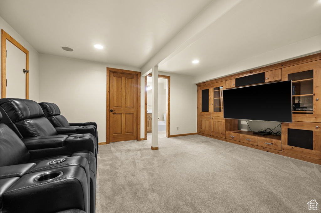 Living area with light colored carpet, baseboards, and recessed lighting