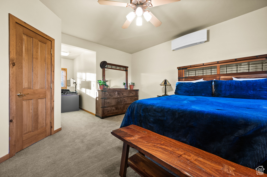 Carpeted bedroom featuring a wall unit AC, baseboards, and a ceiling fan