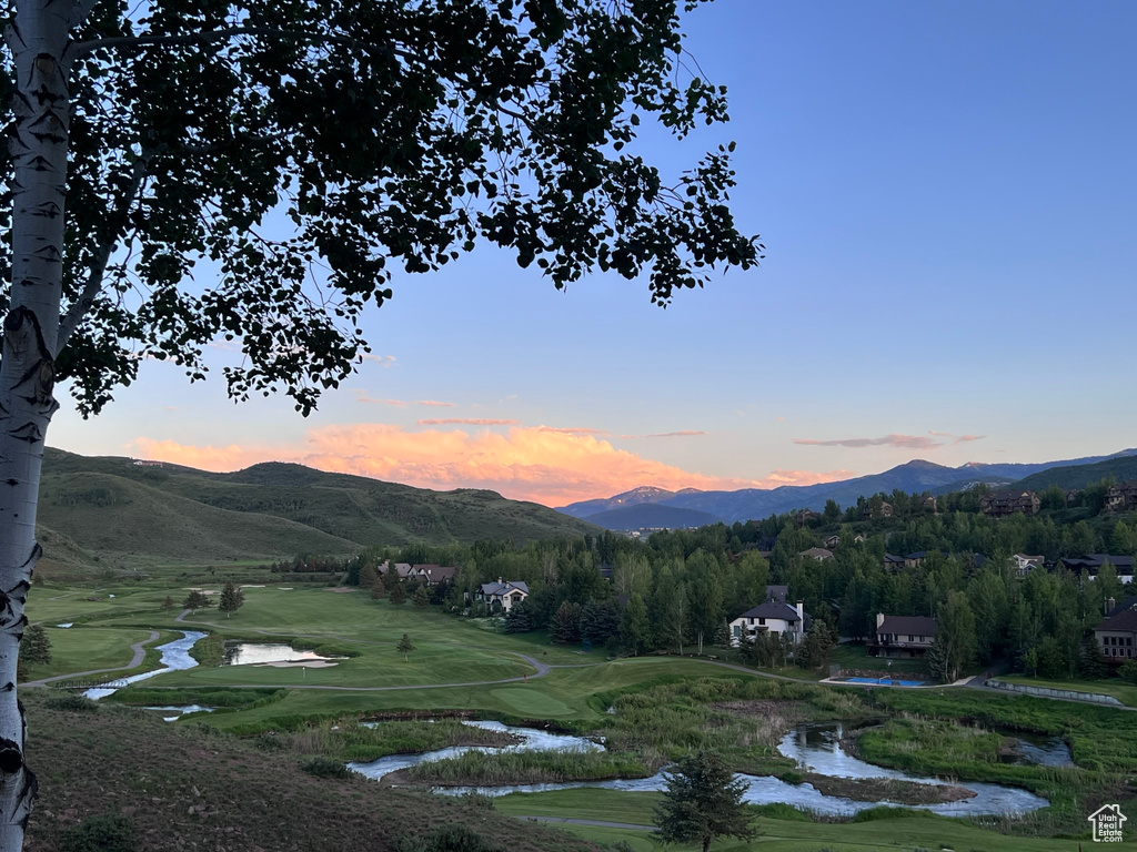 View of mountain backdrop featuring a large body of water and a local golf course