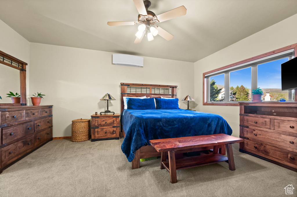 Bedroom featuring carpet, a wall mounted AC, a ceiling fan, and baseboards