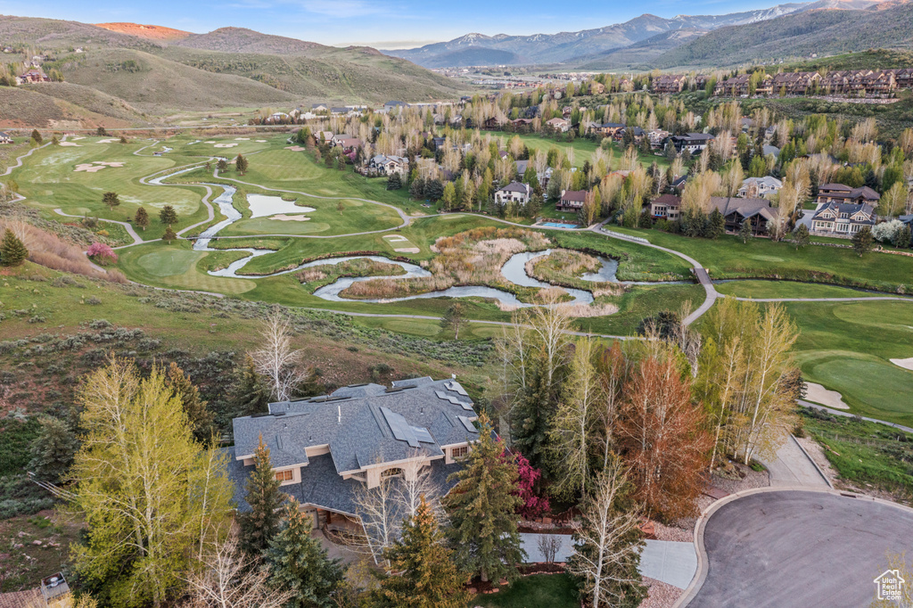 View of property location featuring a local golf course, a mountain backdrop, and nearby suburban area