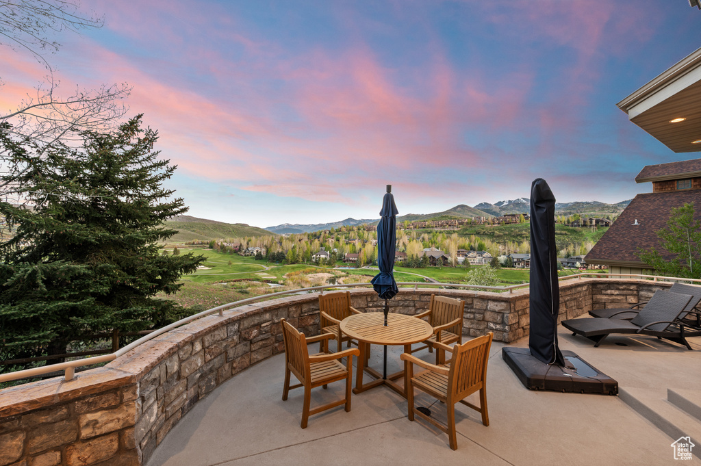 Patio terrace at dusk with a patio, a mountain view, and outdoor dining space