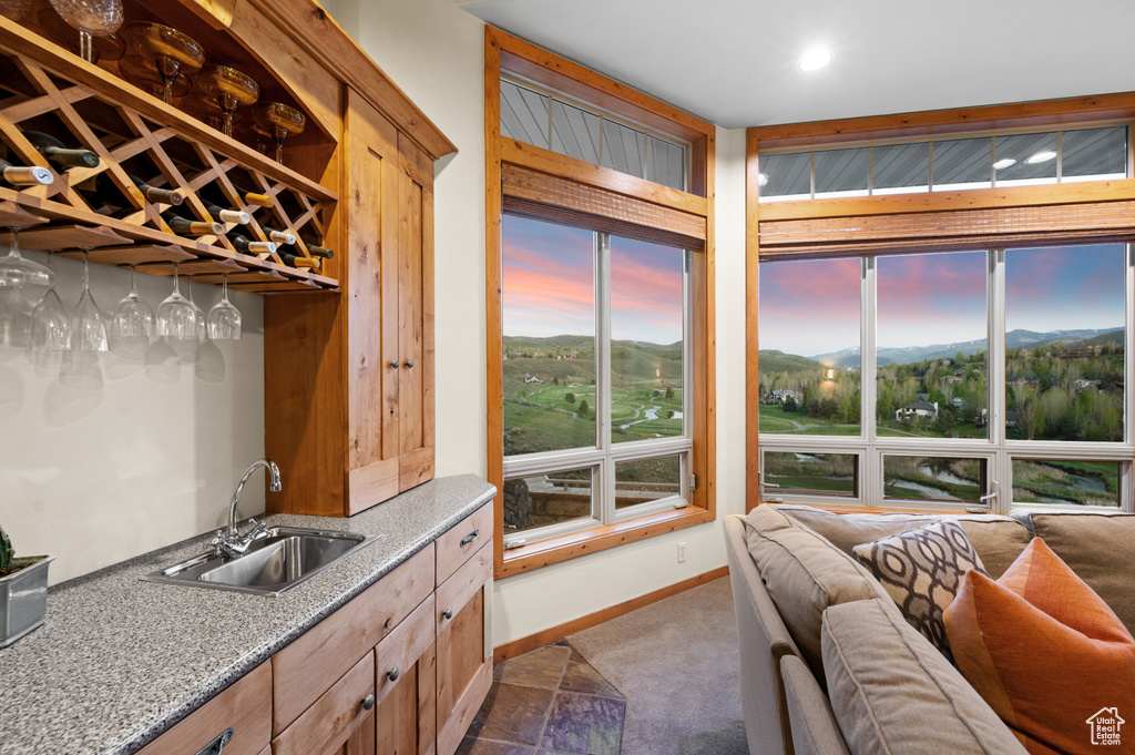 Kitchen featuring a sink, dark colored carpet, baseboards, open floor plan, and recessed lighting