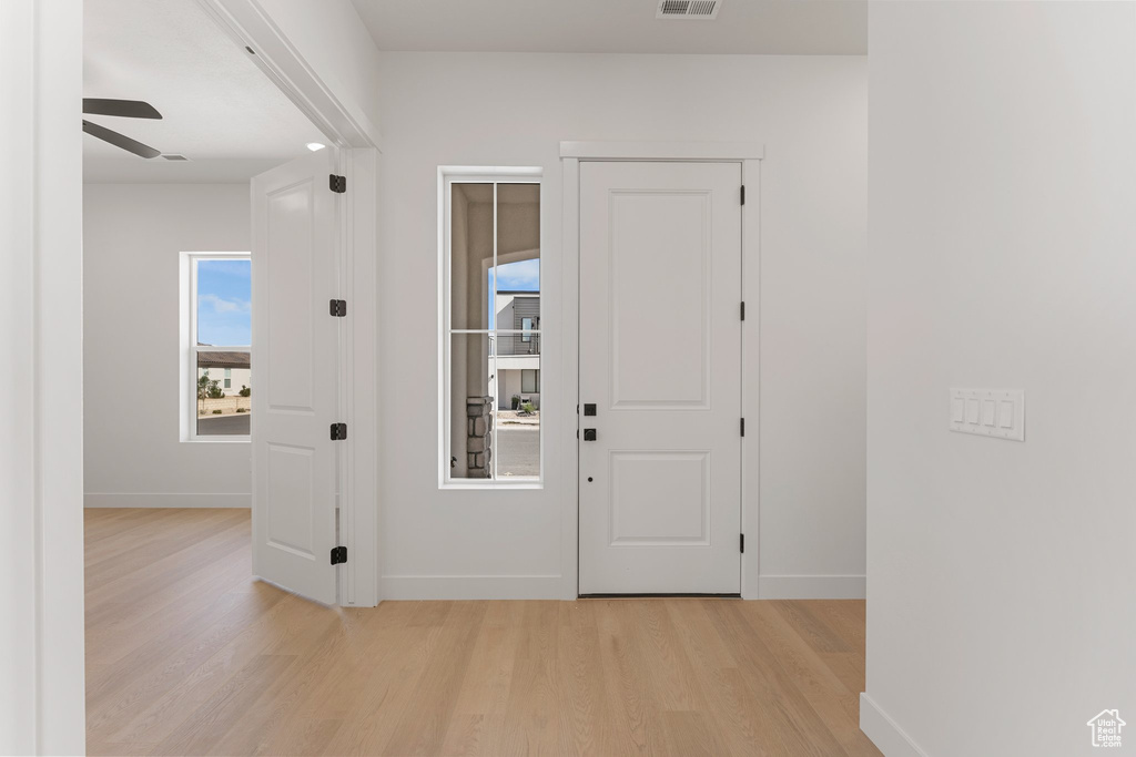 Entryway featuring light wood-style flooring, ceiling fan, and baseboards