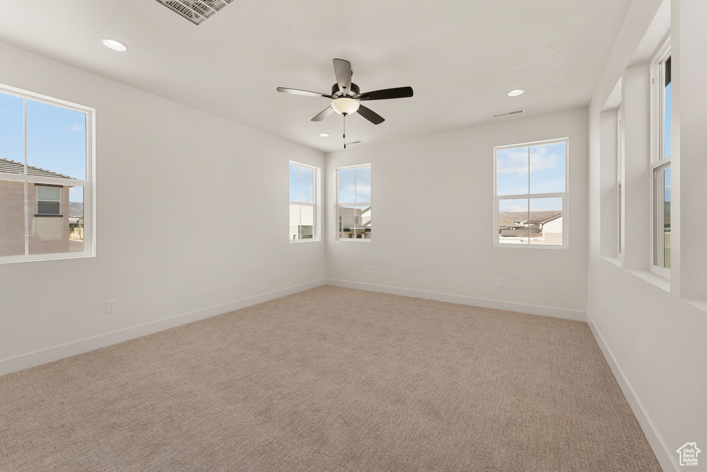 Unfurnished room with healthy amount of natural light, carpet floors, baseboards, recessed lighting, and a ceiling fan
