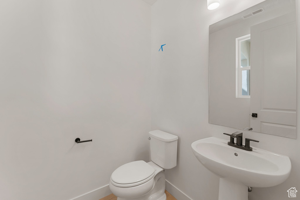 Bathroom featuring baseboards, a sink, and toilet