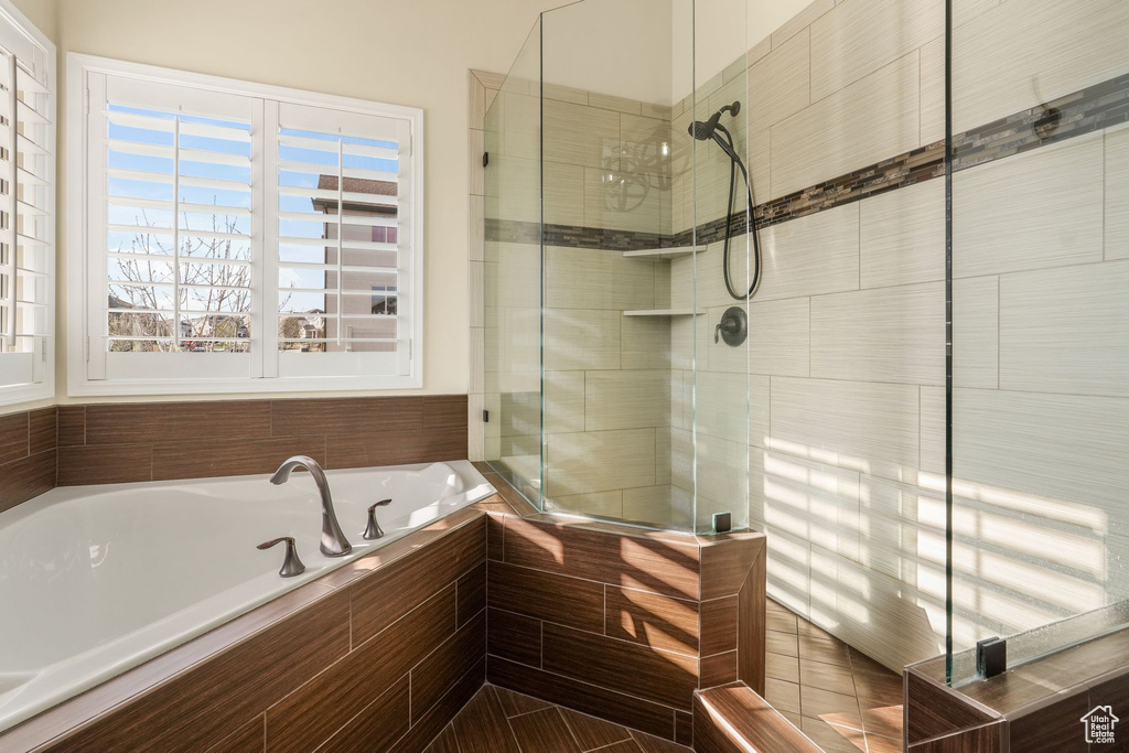Bathroom featuring plenty of natural light, a tile shower, and a bath