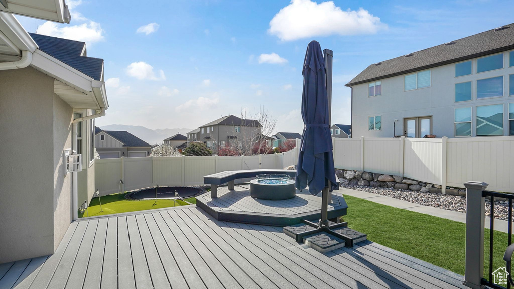Wooden terrace featuring a fenced backyard and a residential view