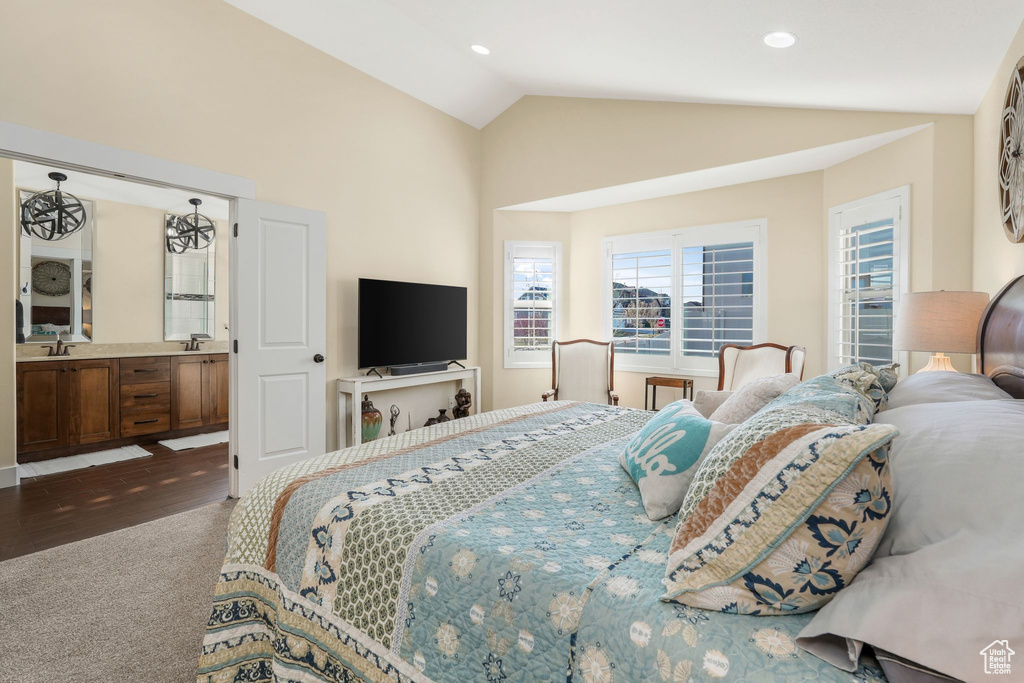 Bedroom with dark colored carpet, vaulted ceiling, a sink, and recessed lighting