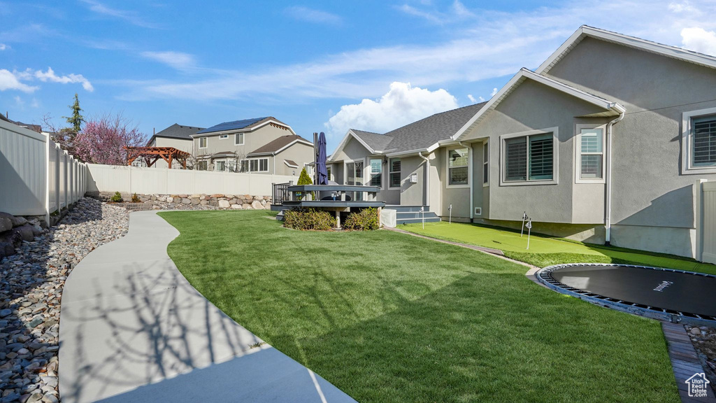 View of yard featuring an area to practice putting, a residential view, and a deck