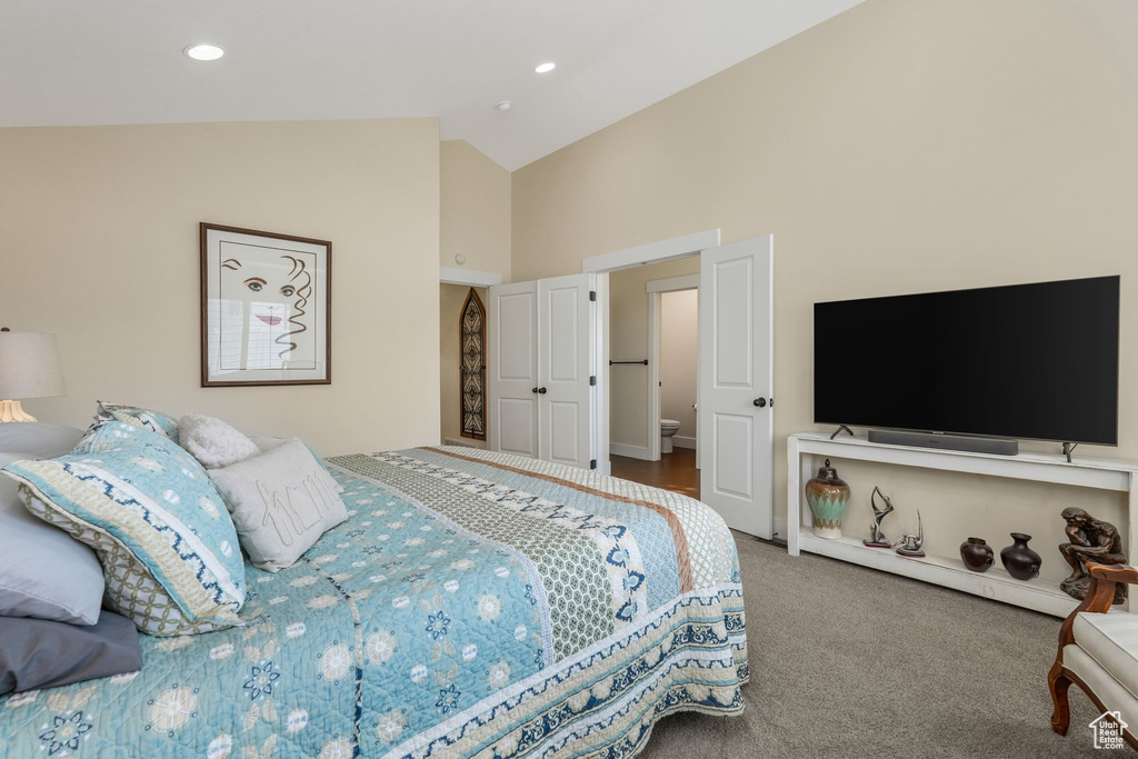 Bedroom with high vaulted ceiling and carpet flooring