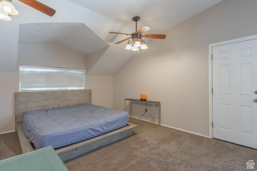 Bedroom with lofted ceiling, carpet floors, baseboards, and a ceiling fan