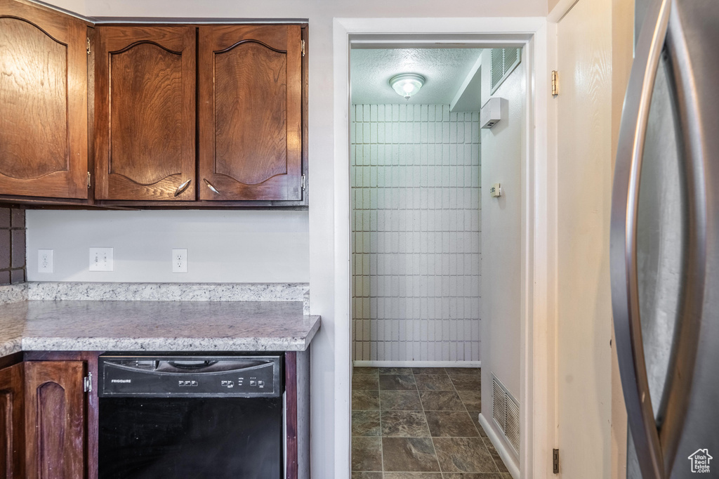 Kitchen with dishwasher, baseboards, and freestanding refrigerator