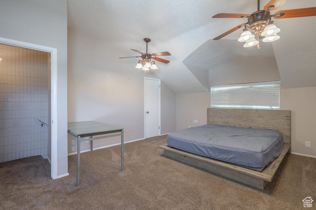 Carpeted bedroom featuring lofted ceiling, baseboards, and ceiling fan