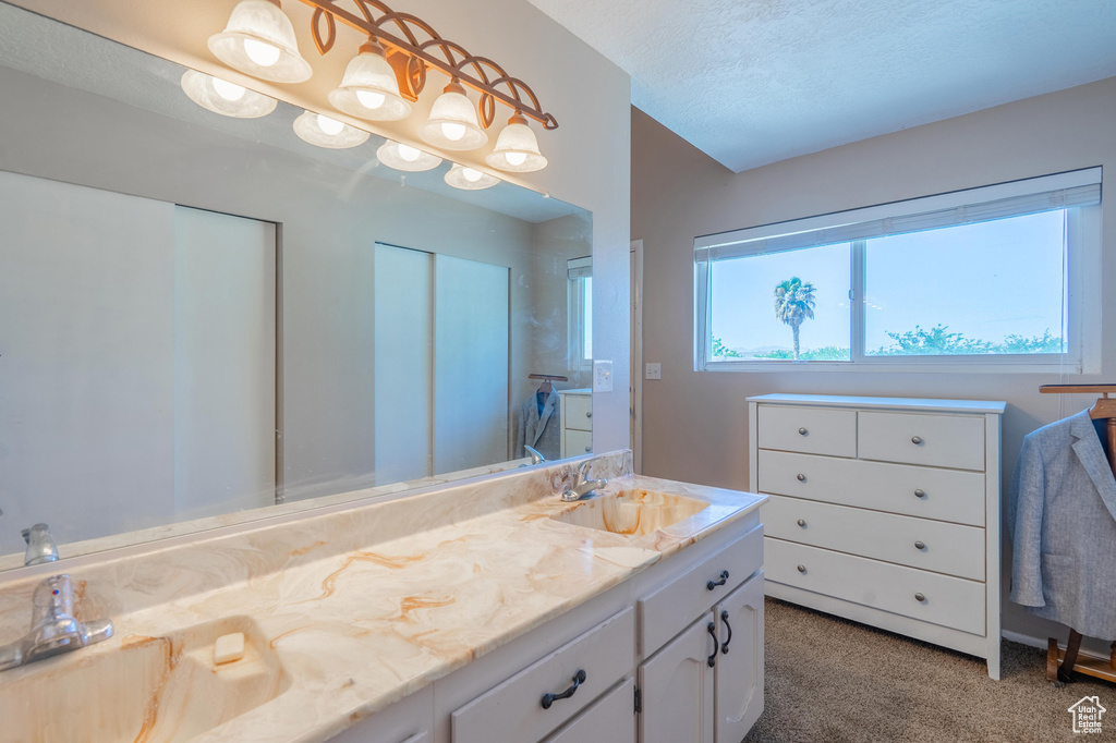 Full bath with double vanity and a textured ceiling