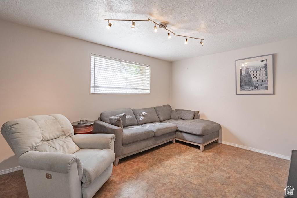 Living area with a textured ceiling and baseboards