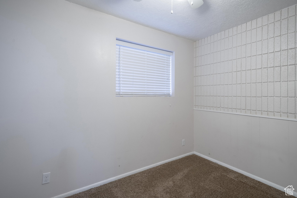Unfurnished room featuring carpet flooring, baseboards, and a textured ceiling