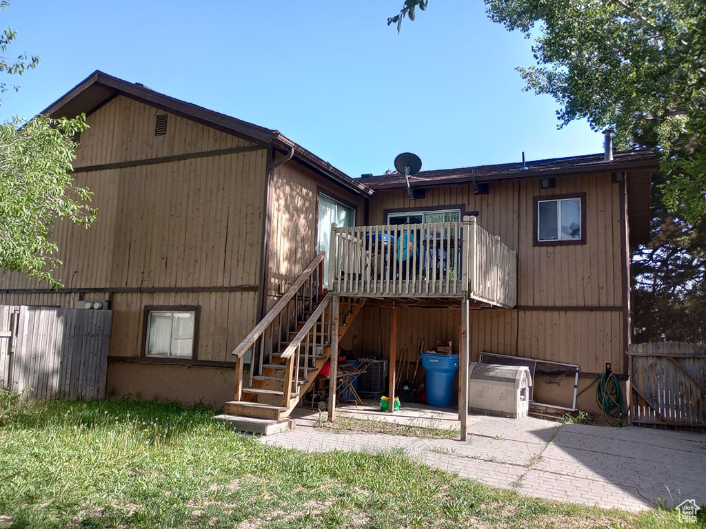 Rear view of property with stairs, a wooden deck, and a patio area