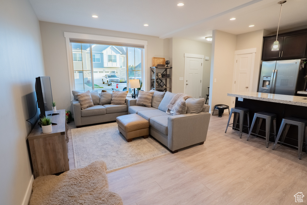 Living room with light wood-type flooring, recessed lighting, and baseboards
