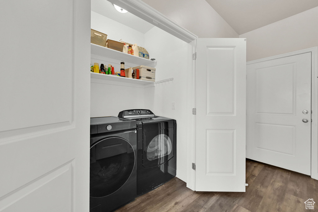 Laundry area with washer and clothes dryer and wood finished floors