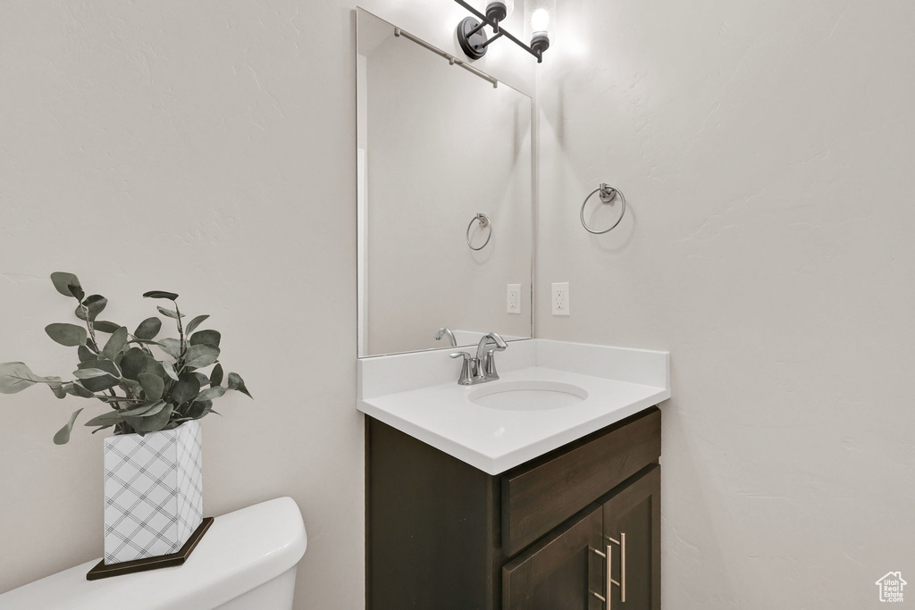 Half bathroom featuring vanity and toilet