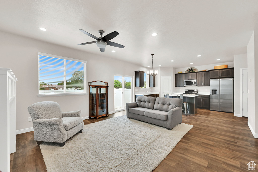 Living area with a ceiling fan, recessed lighting, a chandelier, and baseboards
