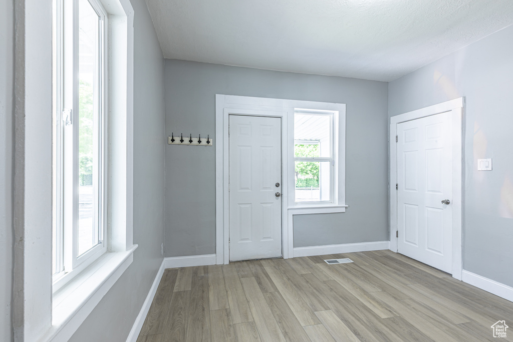 Entryway with light wood-style floors and baseboards