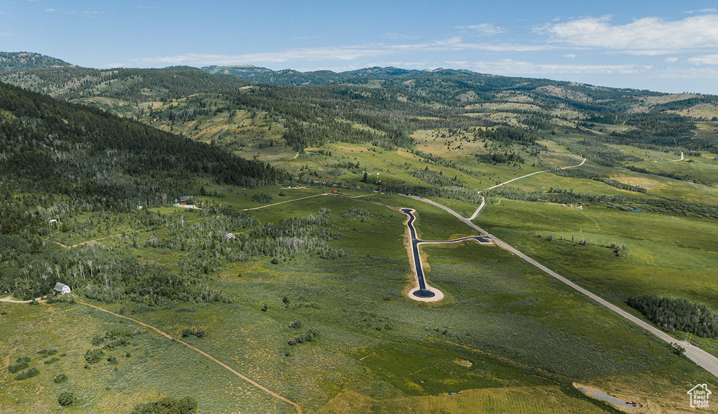 Aerial view of property and surrounding area featuring a mountain backdrop and rural landscape