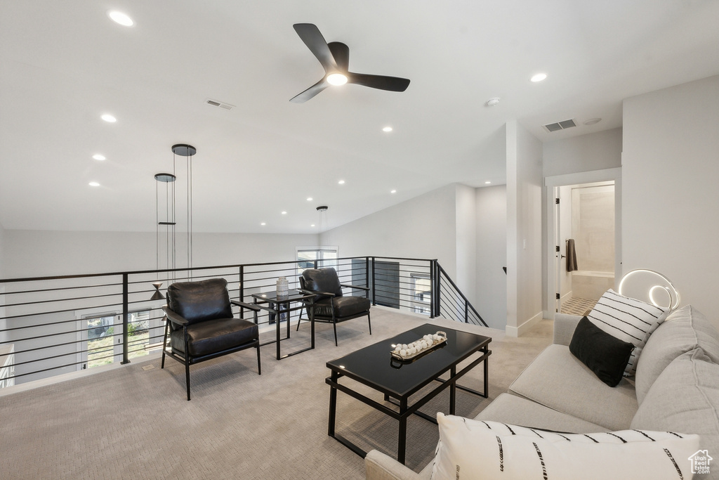 Living area with light colored carpet, a ceiling fan, and recessed lighting