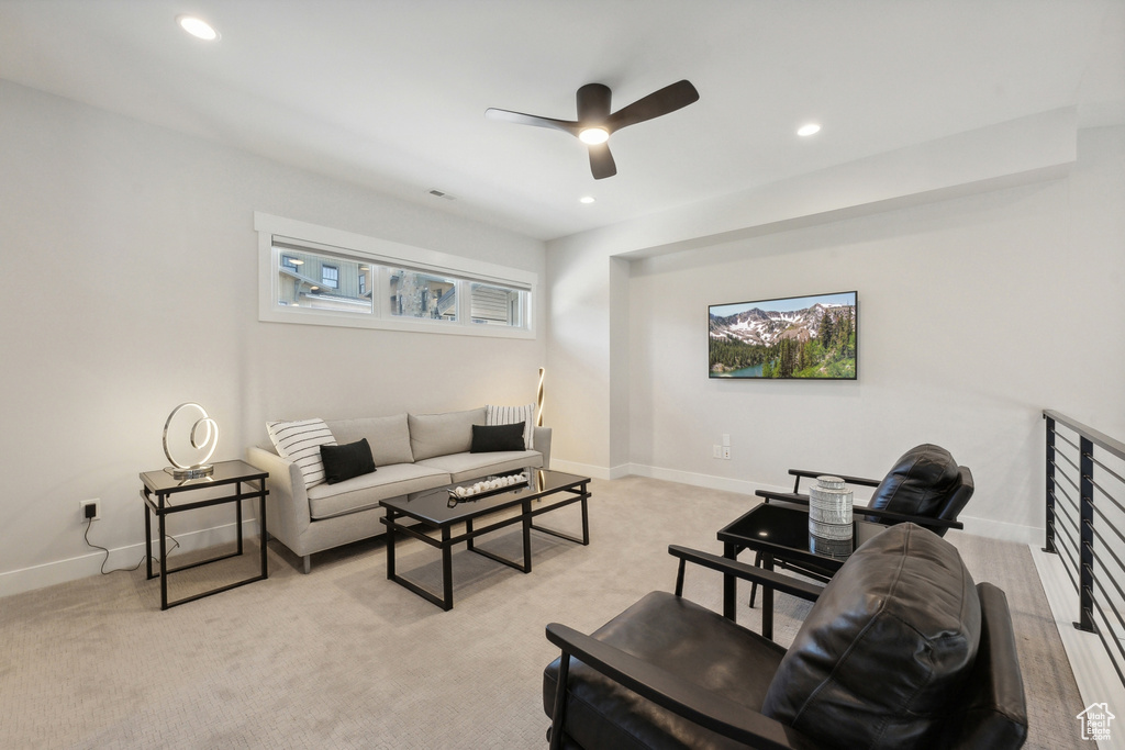Living area with a ceiling fan, baseboards, recessed lighting, and light carpet