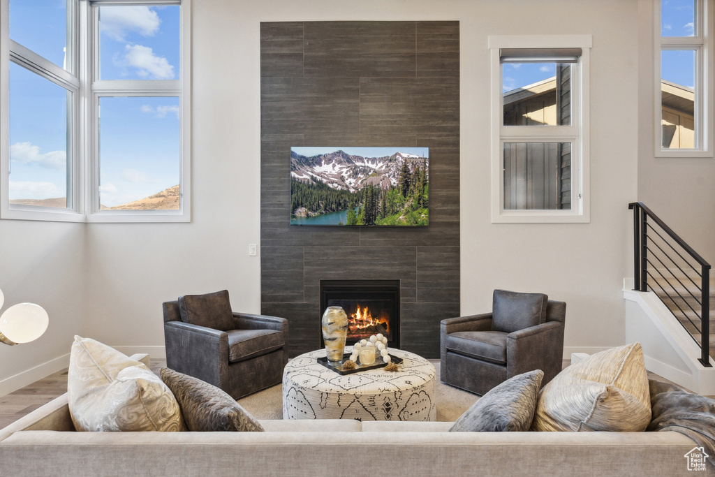 Living area with a fireplace, baseboards, and wood finished floors