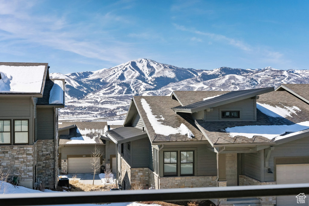 View of front of house with stone siding, a mountain view, and an attached garage