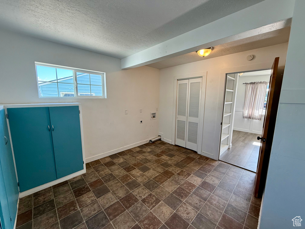 Spare room with a textured ceiling, baseboards, and a smoke detector